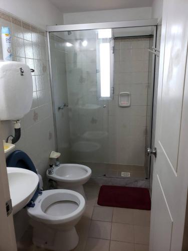 a bathroom with a shower and a toilet and a sink at Frente al mar in Montevideo