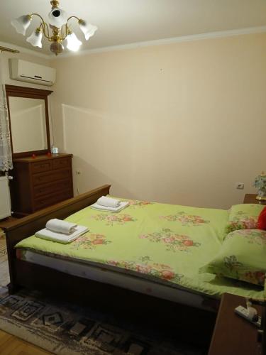 a bedroom with a bed with a dresser and a mirror at SD Apartmani Stan Na Dan in Smederevo