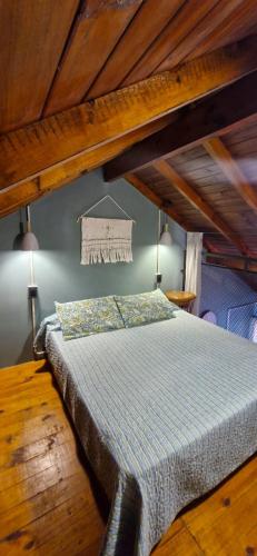 a bedroom with a bed in a room with wooden ceilings at El viejo garage in Mar de Ajó