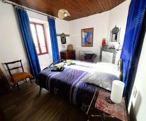 - une chambre dotée d'un lit avec des rideaux bleus dans l'établissement Maison de ferme, prairies sur la colline, étang, à Lanuéjouls-et-Privezac