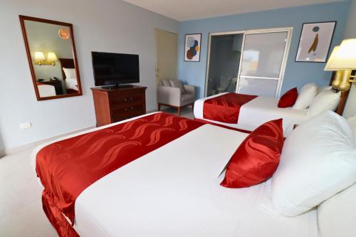a hotel room with two beds and a television at Quality Inn Piedras Negras in Piedras Negras