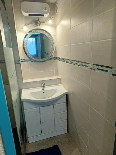 une salle de bain avec un lavabo et un miroir dans l'établissement Mer et dune - Les Caravelles, à Saint-Cyprien