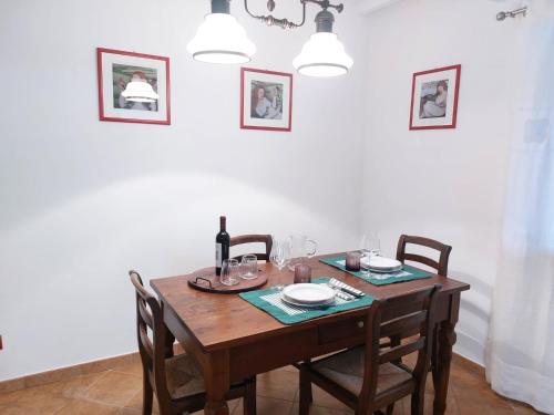 a dining room table with chairs and a bottle of wine at Agriturismo Terre di Anghiari in Anghiari