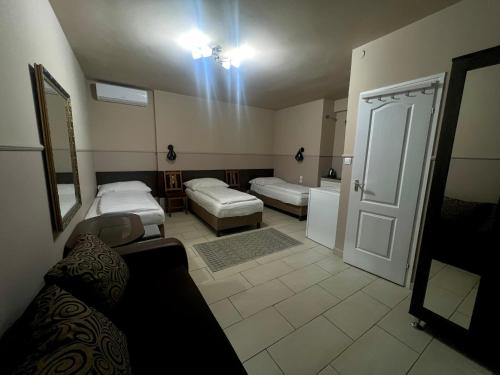 a room with two beds and a bathroom with a door at OP-ART Étterem és Panzió in Monor