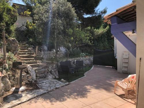 une arrière-cour avec un foyer extérieur et une terrasse avec des chaises dans l'établissement Joli Studio proche de la Mer à la Couronne, à Martigues