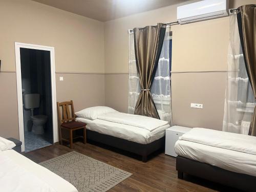 a room with two beds and a mirror at OP-ART Étterem és Panzió in Monor