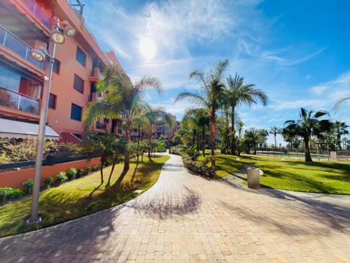 a brick walkway with palm trees next to a building at La casa de Bimba Playa Granada in Motril