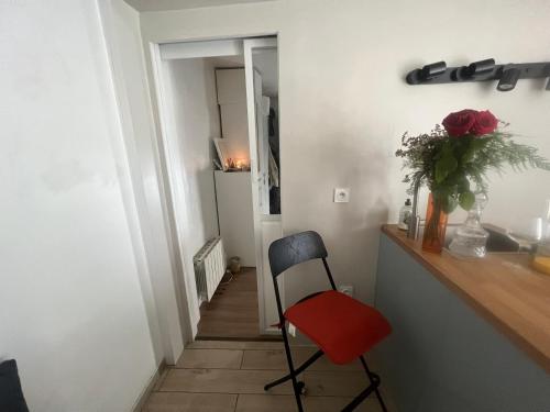 un escalier avec une chaise et un vase de fleurs dans l'établissement Appartement le menilmontant, à Paris