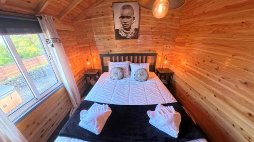 a bedroom with a bed in a wooden cabin at Adega da Quinta - Casa da Gigi in Madalena