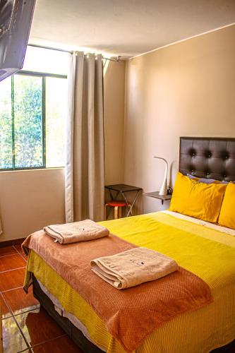 a bedroom with a bed with two towels on it at Del Valle House in Ica