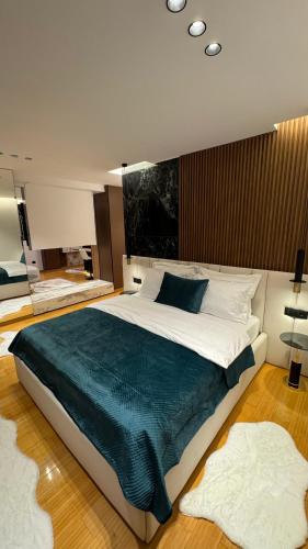 a bedroom with a large bed with a blue blanket at Stayinn Emerald Shkoder in Shkodër