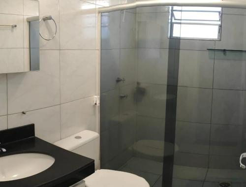 a bathroom with a shower and a toilet and a sink at Apto 2 quarto completo com vaga-proximo shopping contagem in Contagem