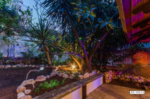 a garden with a tree and a stone wall at Beautiful Countryside House in Tiberias