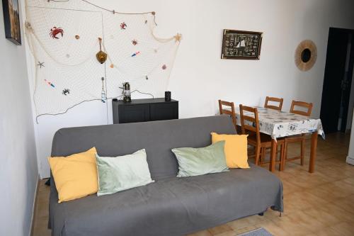 un salon avec un canapé et une table dans l'établissement Maisonnette proche des plages, 4-5 personnes, à Mireval