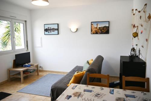 un salon avec un canapé et une table dans l'établissement Maisonnette proche des plages, 4-5 personnes, à Mireval