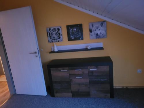 a room with a fireplace with pictures on the wall at Alexas Ferienwohnung in Windischeschenbach
