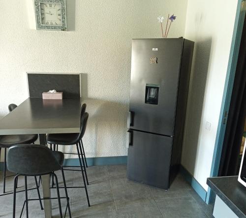 une cuisine avec une table et un réfrigérateur dans l'établissement Logement plage, à Saint-Cyprien