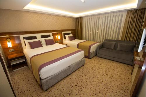 a hotel room with two beds and a couch at Ruba Palace Thermal Hotel in Bursa