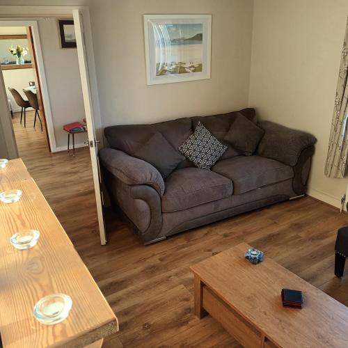 a living room with a brown couch and a table at Tigh a' Chreagain in Stockinish Island