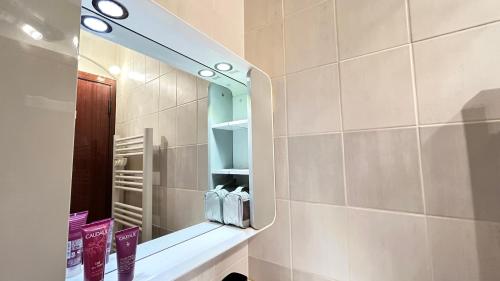 La salle de bains est pourvue d'un miroir mural. dans l'établissement Studio cosy Vue imprenable Aix Les Bains, à Aix-les-Bains