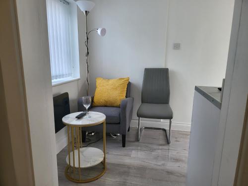 a living room with a chair and a table at Evabrite Homes in Dartford