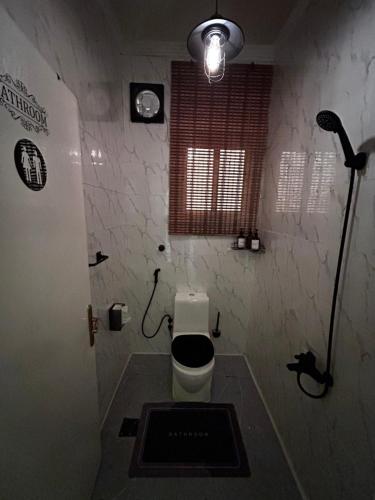 a small bathroom with a toilet with a window at HOMEY iNN in Al Madinah