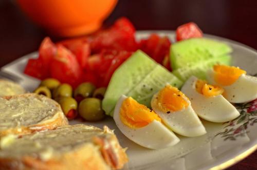 a plate of food with eggs and fruit on it at Villa Jordan in Ohrid