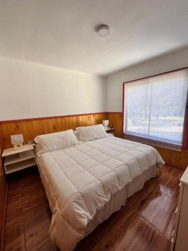 ein Schlafzimmer mit einem großen Bett und einem Fenster in der Unterkunft Cabaña estilo mediterránea in Pucón