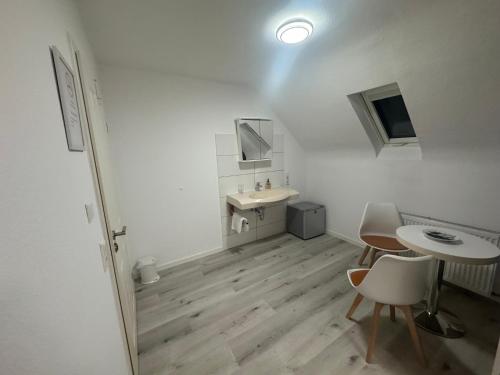 a white bathroom with a sink and a table at Dasluki in Köngen