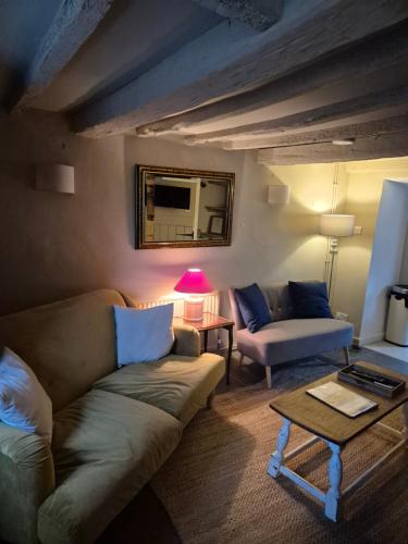 a living room with a couch and a table at Cosy Cotswold Cottage in Stow on the Wold