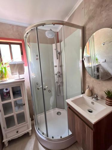 ein Badezimmer mit Dusche und Waschbecken in der Unterkunft Cabaña estilo mediterránea in Pucón