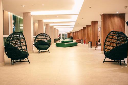 a hospital hallway with chairs and tables in aermottermottermottermott at Costeira Palace Beach Resort All Inclusive in Natal