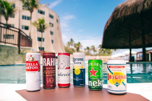 a group of cans sitting on a table near a pool at Costeira Palace Beach Resort All Inclusive in Natal