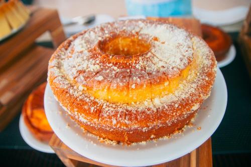 a cake on a white plate on a table at Costeira Palace Beach Resort All Inclusive in Natal