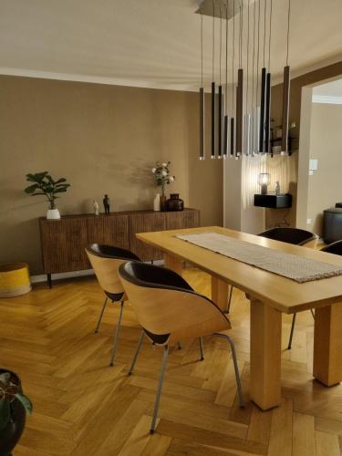 a dining room with a wooden table and chairs at Im Zentrum von Leverkusen, helle 3-Zimmerwohnung 80 m2 in Leverkusen