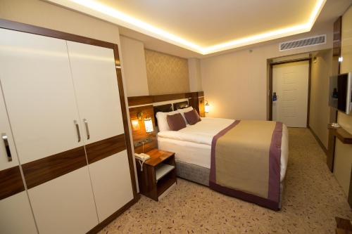 a hotel room with a bed and a closet at Ruba Palace Thermal Hotel in Bursa