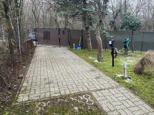 a brick sidewalk next to a fence with a parking meter at Villa Lena Nagymaros in Nagymaros
