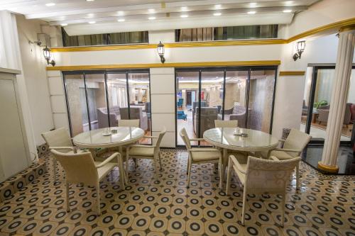 a restaurant with two tables and chairs and windows at Ruba Palace Thermal Hotel in Bursa