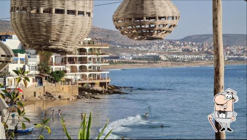a view of a beach with two chandeliers and the ocean at golden sand appartment 3 in Agadir