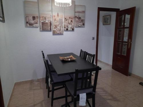 a dining room with a black table and chairs at House close to airport in El Prat de Llobregat