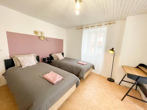 une chambre avec deux lits et une fenêtre dans l'établissement Meygal Color - WiFi - 3 étoiles - 20min du Puy, à Lantriac