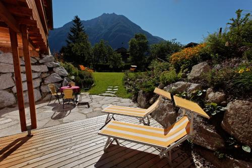 two chairs and a table on a wooden deck at Residence Margareth in Campo Tures