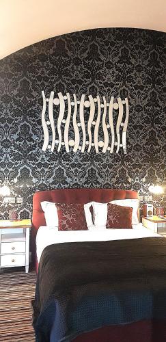 a bedroom with a large bed with a black wall at Burton Stone Inn in York