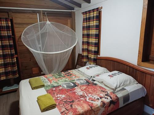 a bed with a net on top of it at Soleil couchant in Bouillante