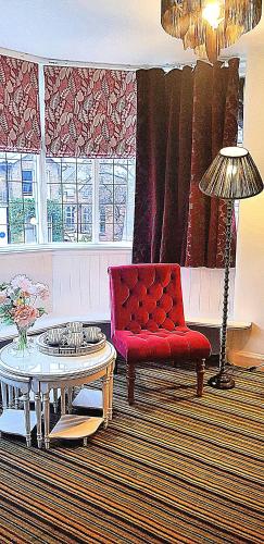 a living room with a red couch and a table at Burton Stone Inn in York