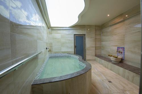 a large bathroom with a hot tub in a room at Ruba Palace Thermal Hotel in Bursa