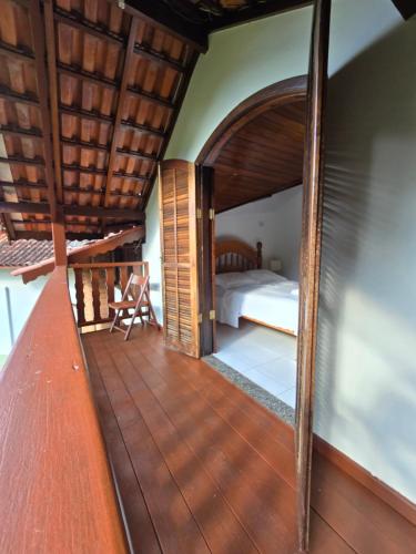 a room with a bed and a wooden floor at Pousada Bela Mauá in Itatiaia