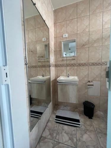 a bathroom with two sinks and a mirror at Pousada Bela Santa in Aparecida