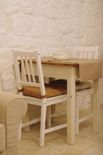 a table with two chairs and a table and a table and a table at Casa Matteotti in Conversano