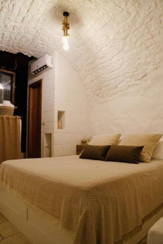 a bedroom with a large bed with a stone wall at Casa Matteotti in Conversano